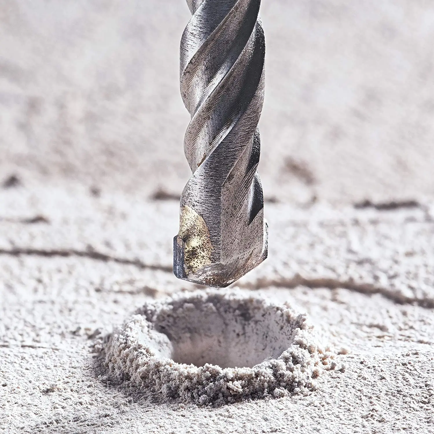 Close up of concrete drill bit above a drilled hole